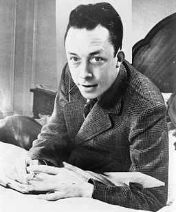 albert_camus_gagnant_de_prix_nobel_portrait_en_buste_pose_au_bureau_faisant_face_a_gauche_cigarette_de_tabagisme